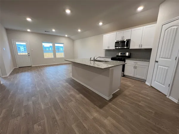 a kitchen with sink wooden floor and stainless steel appliances