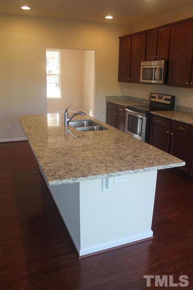 104 Hope Valley Road Knightdale, NC 27545 - Photo 10 of 15 a kitchen with kitchen island granite countertop a sink a counter top space cabinets and stainless steel appliances