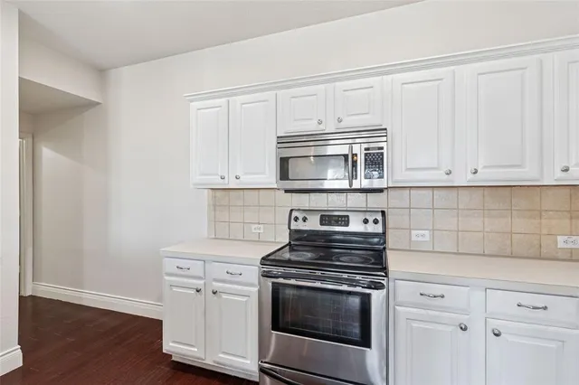 a kitchen with a sink cabinets stainless steel appliances and a window