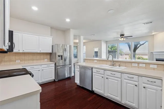a kitchen with a sink stove top oven and cabinets