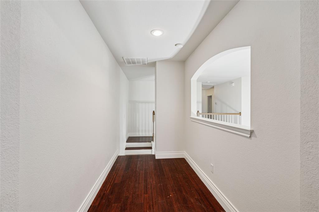 4509 Gila Bend Lane Fort Worth, TX 76137 - Photo 17 of 28 a view of a hallway with wooden floor and a bathroom