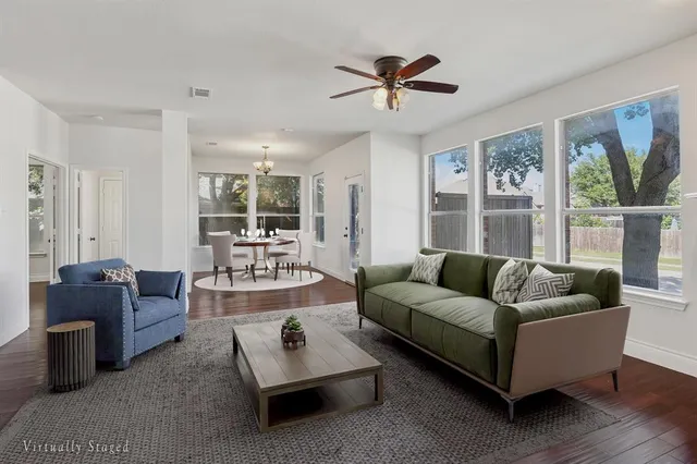 a living room with furniture a fireplace and a large window