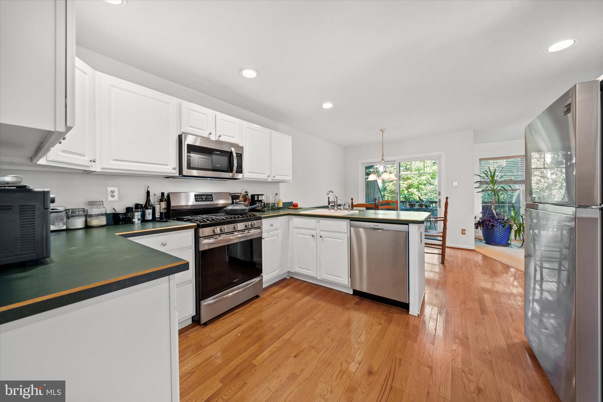 1015 Adams Way West Chester, PA 19382 - Photo 20 of 48 a kitchen with granite countertop a stove top oven a sink dishwasher a refrigerator and white cabinets with wooden floor