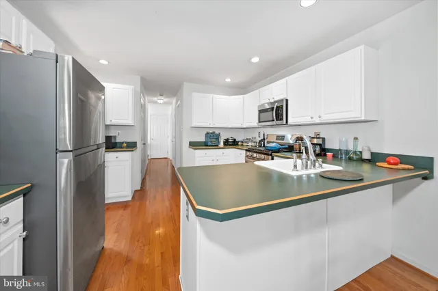 a kitchen with stainless steel appliances granite countertop a sink a refrigerator and a stove