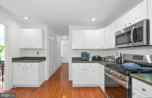 a kitchen with granite countertop a sink a stove and wooden cabinets