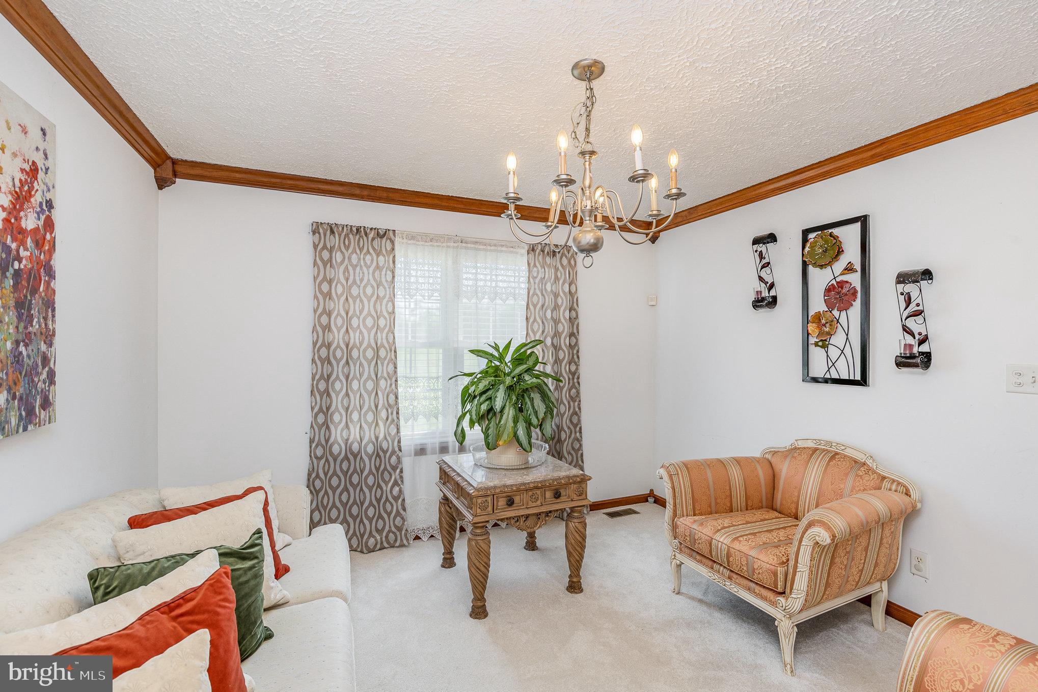 9121 Will Loop King George, VA 22485 - Photo 11 of 52 a living room with furniture and a chandelier
