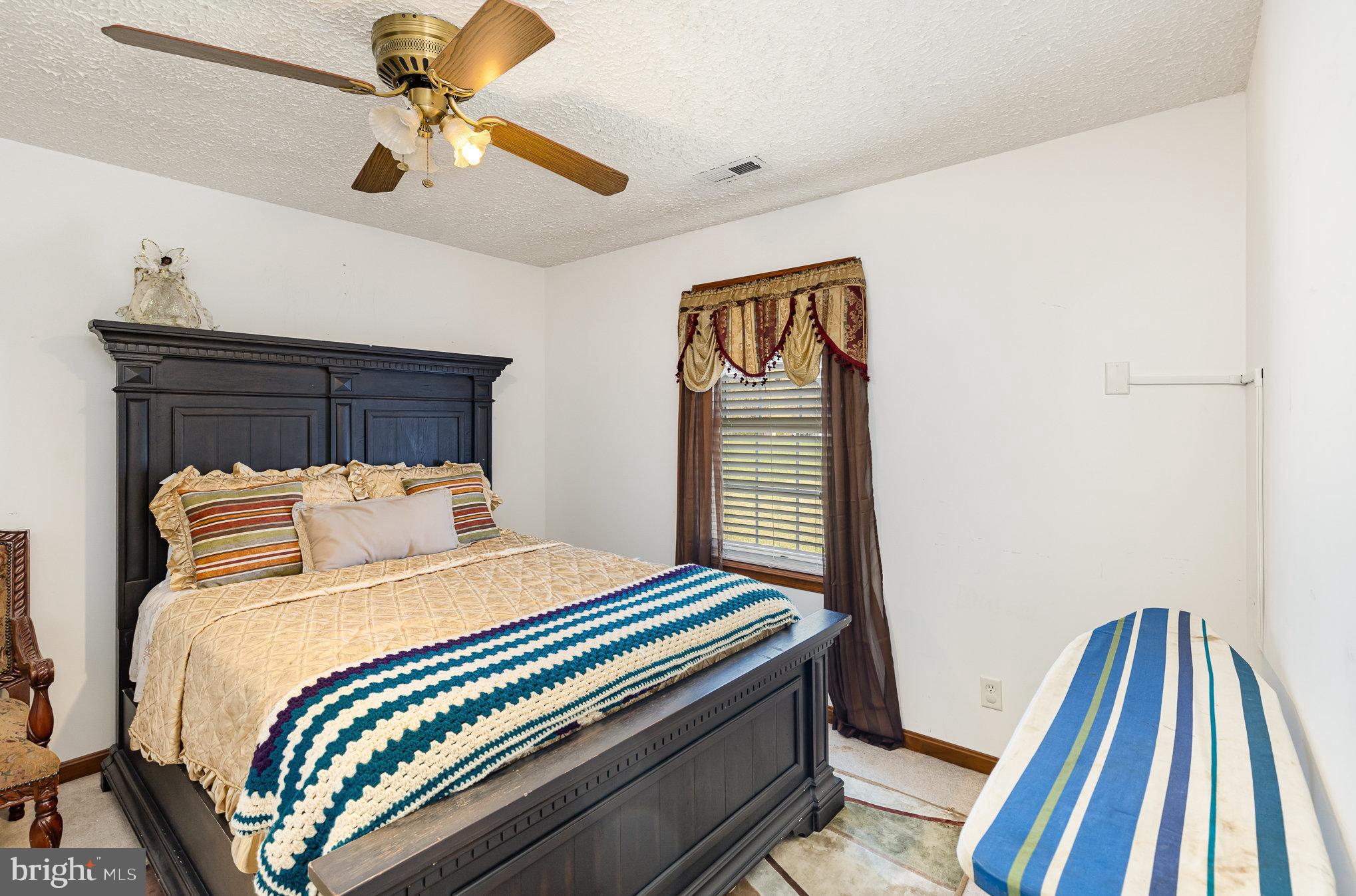 9121 Will Loop King George, VA 22485 - Photo 28 of 52 a bedroom with a bed and a chandelier