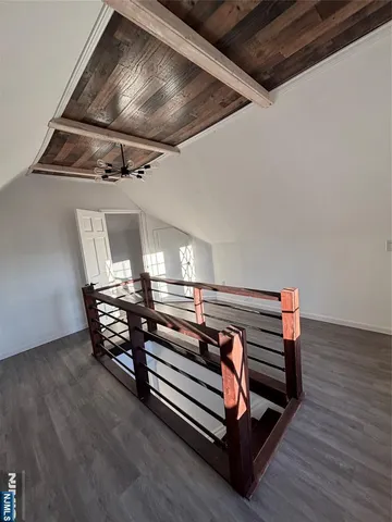 a view of a hallway with wooden floor and stairs