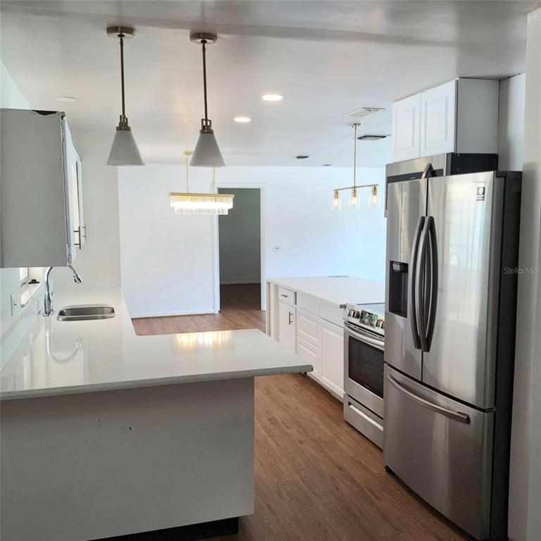 514 Spring Oaks Boulevard Altamonte Springs, FL 32714 - Photo 2 of 16 a kitchen with stainless steel appliances a refrigerator a sink a stove and white cabinets