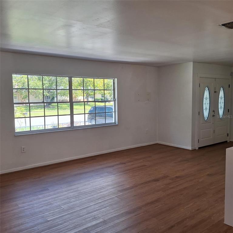 514 Spring Oaks Boulevard Altamonte Springs, FL 32714 - Photo 4 of 16 a view of an empty room with wooden floor and a window