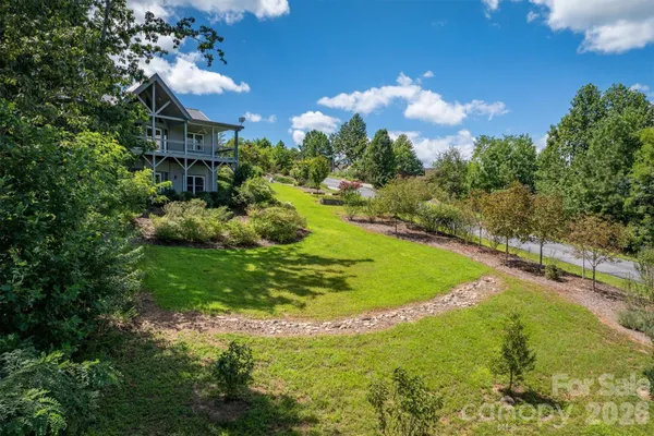 a view of a house with a big yard and large trees