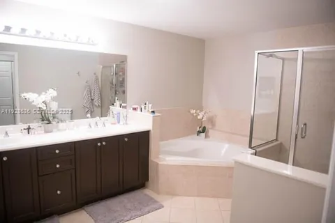 a bathroom with a tub sink and mirror