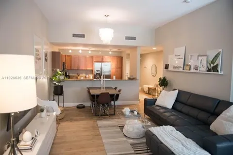 a living room with furniture and view of kitchen
