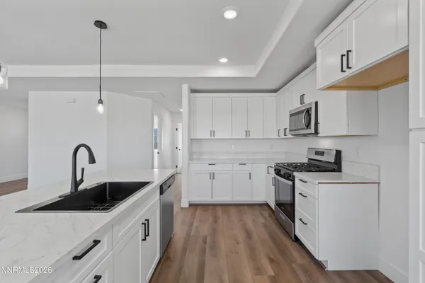 a kitchen with white cabinets appliances and sink