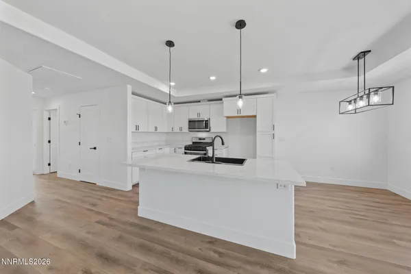 a kitchen with kitchen island white cabinets stainless steel appliances and wooden floor
