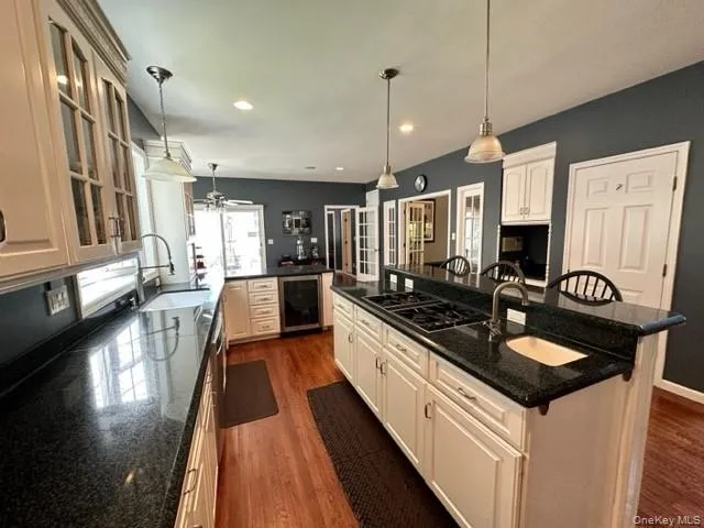 a kitchen with stainless steel appliances granite countertop a sink a stove and a wooden floors
