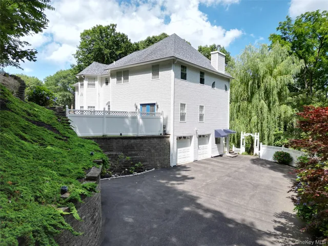 a view of a white house with a yard and large tree