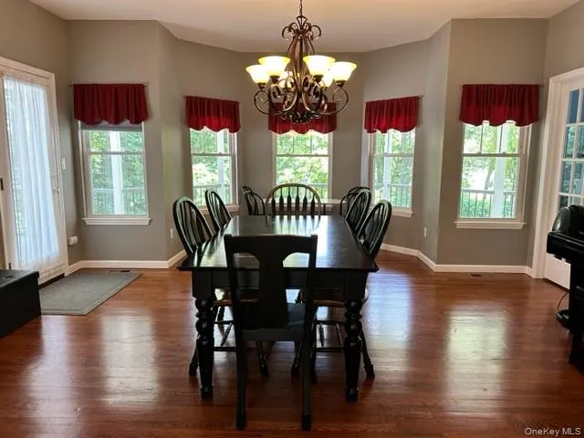 a view of a dining room with furniture a chandelier and wooden floor