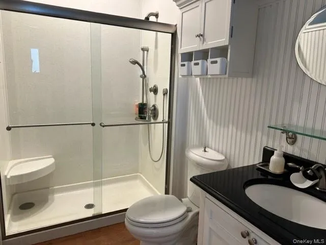 a bathroom with a sink a toilet and shower