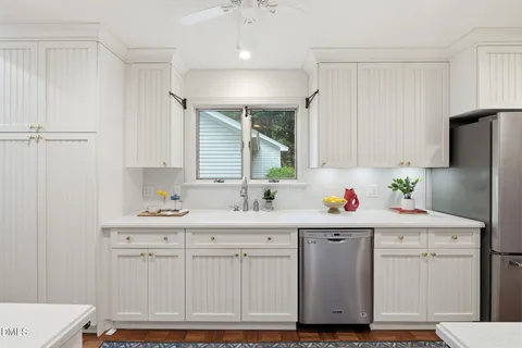 a kitchen with white cabinets and white appliances