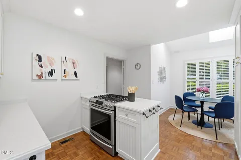 a kitchen that has a stove and a table in it