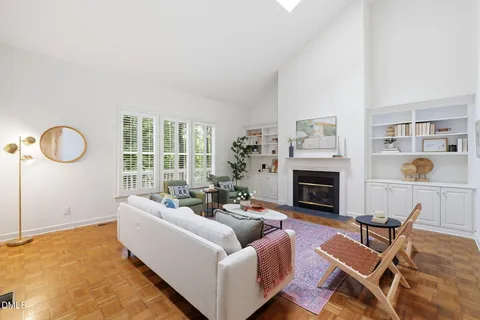 a living room with furniture a fireplace and a large window
