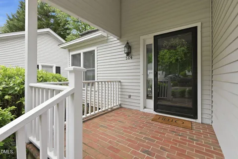 a porch with a wooden floor and next to a yard