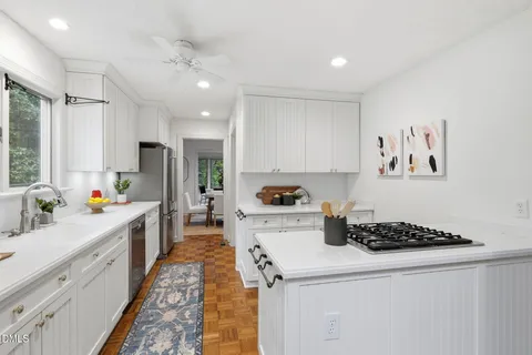 a kitchen with sink a stove and cabinets