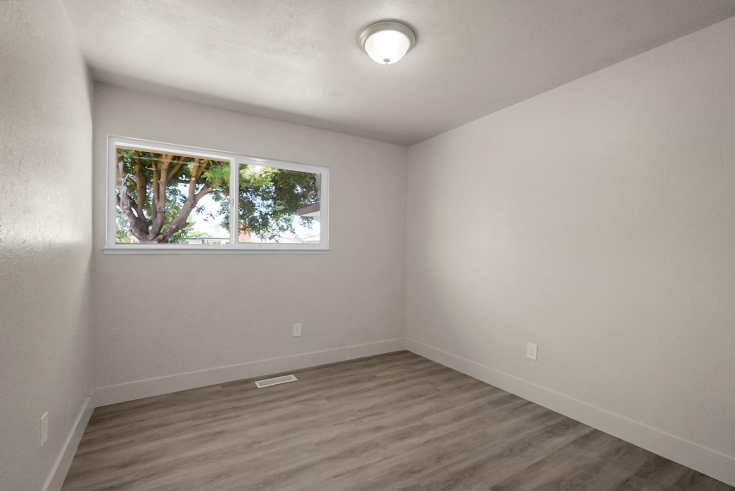 2832 Fowler Road Ceres, CA 95307 - Photo 14 of 28 an empty room with wooden floor and window