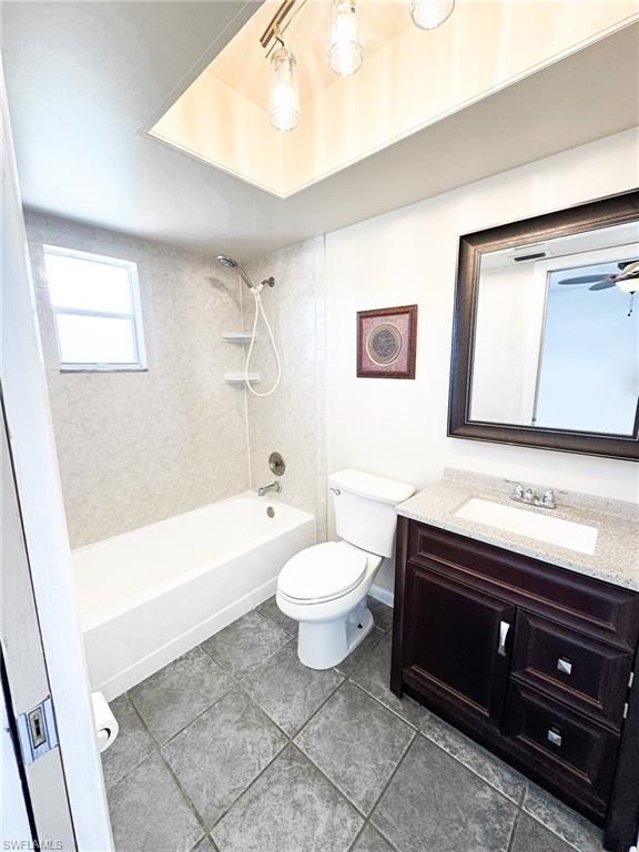 18584 Sebring Road Fort Myers, FL 33967 - Photo 14 of 25 Full bathroom featuring vanity, toilet, tiled shower / bath combo, and tile patterned flooring.