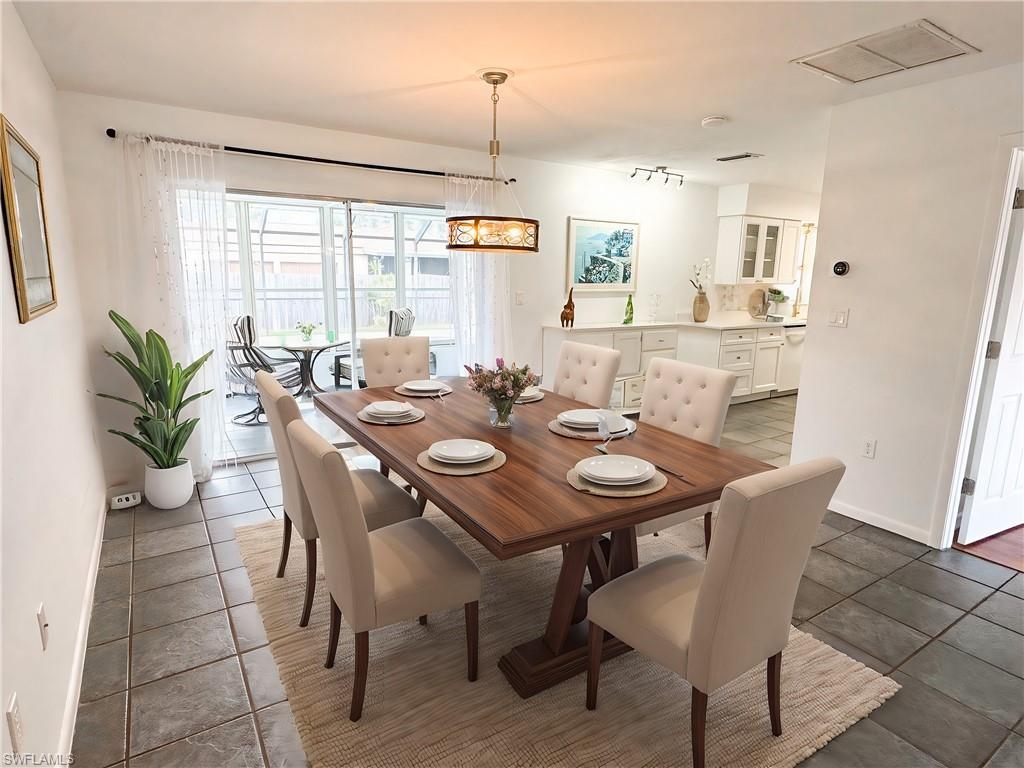 18584 Sebring Road Fort Myers, FL 33967 - Photo 16 of 25 Tiled dining area with an inviting chandelier. This photo has been virtually staged.