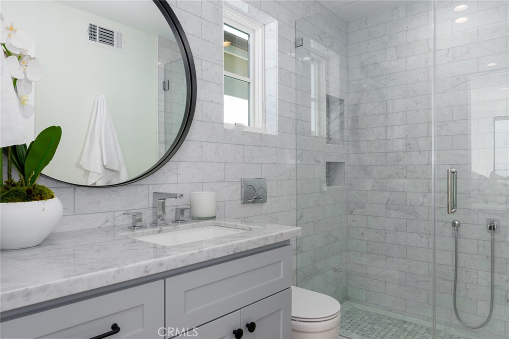 1025 West Balboa Boulevard Newport Beach, CA 92661 - Photo 41 of 70 a bathroom with a granite countertop sink a toilet and a mirror