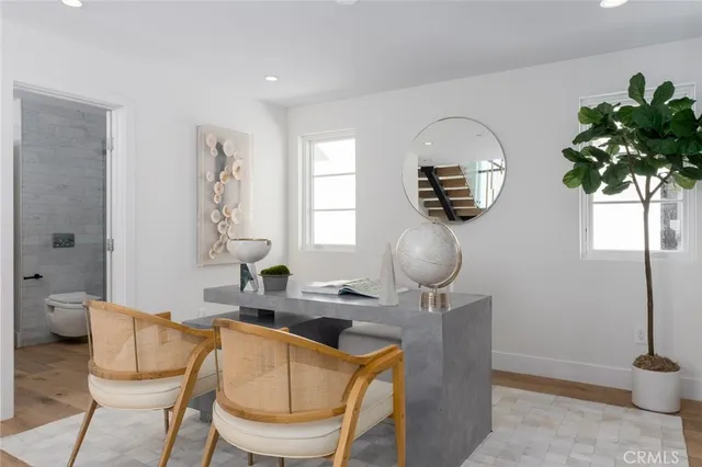 a view of a patio with couches and table and chairs under an umbrella with a fire pit