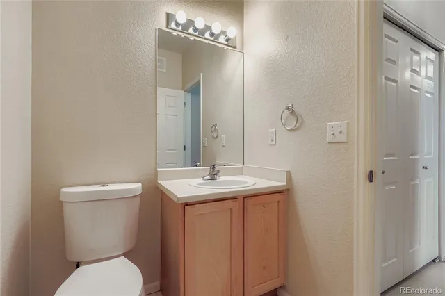 a bathroom with a toilet a sink and mirror