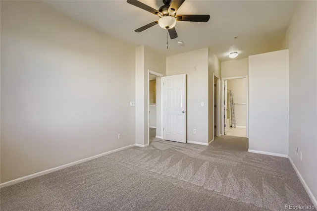 a view of an empty room and a ceiling fan