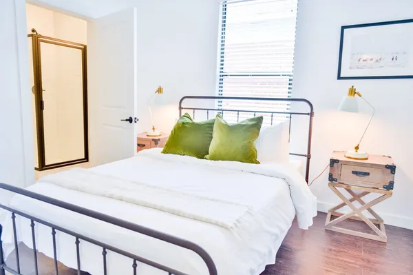 a bedroom with a bed and wooden floor