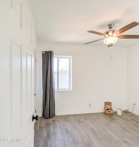 an empty room with windows and fan