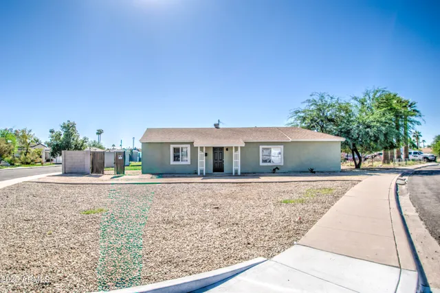 a front view of house with yard and trees in the background