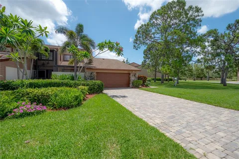 a front view of a house with a yard and potted plants