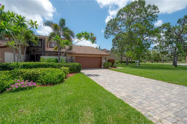 a front view of a house with a yard and potted plants