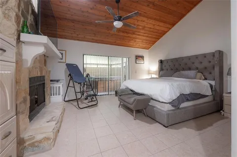 a spacious bedroom with a bed a chandelier and flat screen tv