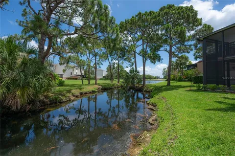 a view of a house with a yard and potted plants