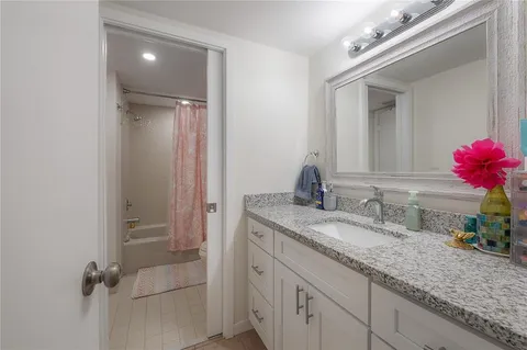 a bathroom with a granite countertop sink mirror and vanity