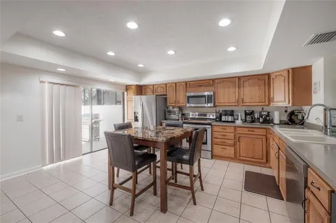 a kitchen with stainless steel appliances granite countertop a stove a sink a dining table and chairs
