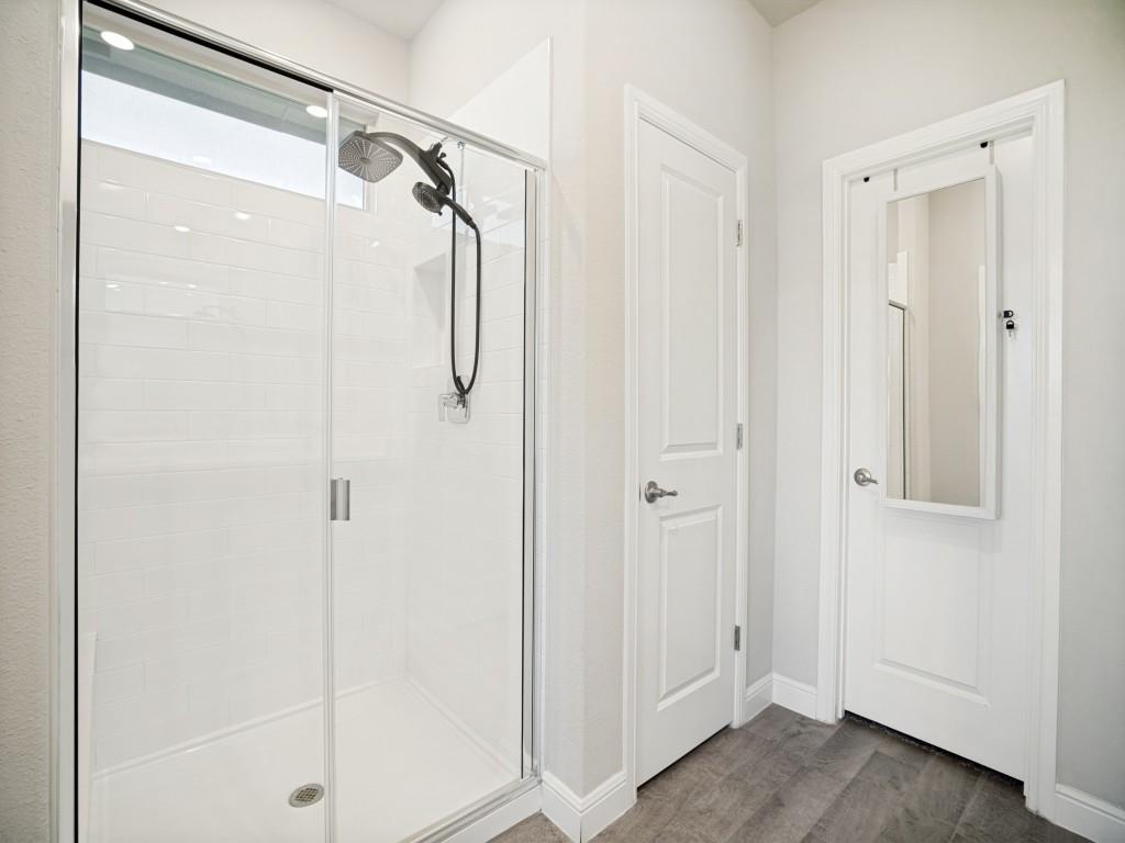 1612 Reed Drive Krum, TX 76249 - Photo 15 of 25 Walk-in shower featuring a sliding glass door, white subway tile surround, and a rain shower head with an additional handheld sprayer