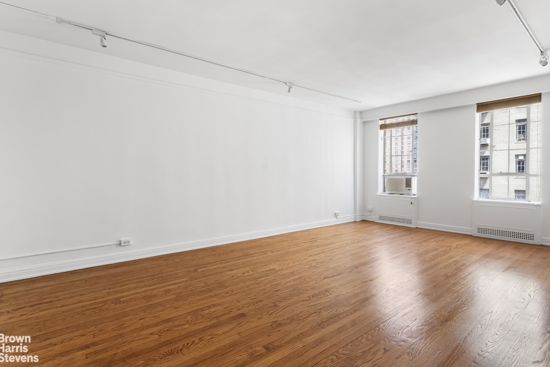 353 West 56th Street, Unit 9F Manhattan, NY 10019 - Photo 2 of 10 a view of an empty room with wooden floor and a window