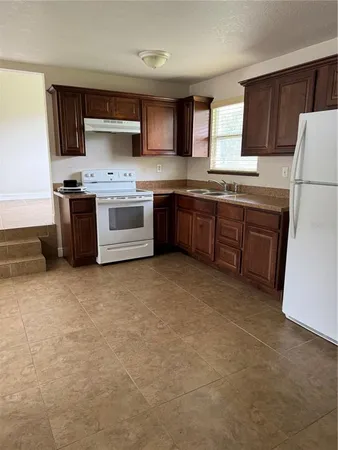 a kitchen with stainless steel appliances a refrigerator sink and cabinets