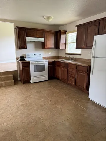 a kitchen with stainless steel appliances a refrigerator sink and cabinets