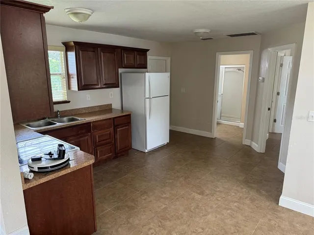 a kitchen with stainless steel appliances granite countertop a refrigerator stove and sink