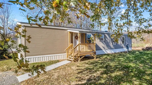 a view of a house with a small yard and wooden fence